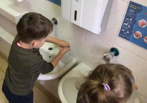 Adam i Zosia ćwiczą w praktyce prawidłowe mycie rąk.